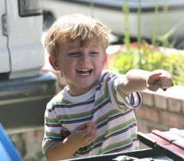 smiling boy playing with toy race cars